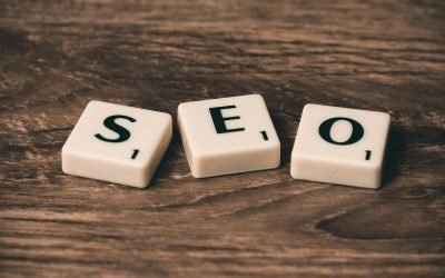 Tuiles de Scrabble avec le mot « SEO » sur une surface en bois. Idéales pour les thèmes de marketing numérique.