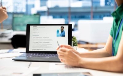 Une personne travaille sur un ordinateur portable, affichant un CV professionnel soigné.