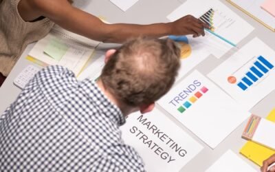 Une équipe discute de stratégies marketing dans un environnement de bureau moderne, avec des graphiques et des documents.