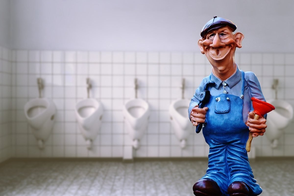 Statue d'homme en uniforme bleu dans salle de bains avec urinoirs Statue d'homme en uniforme bleu dans salle de bains avec urinoirs