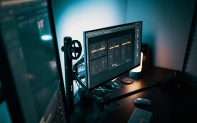 Un poste de travail avec écran clavier souris et micro dans une pièce sombre