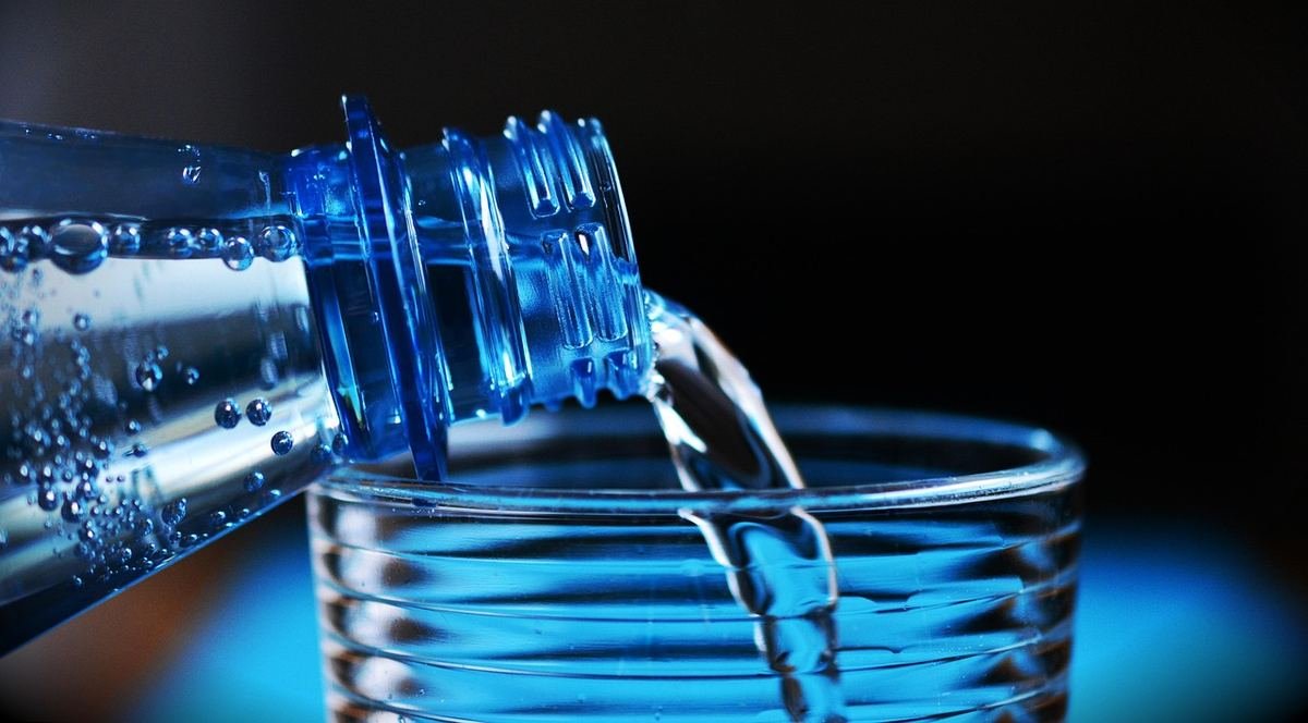 Eau qui coule d'une bouteille dans un verre Eau qui coule d'une bouteille dans un verre
